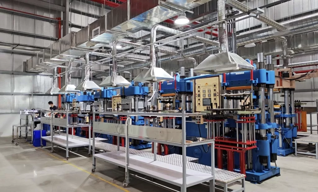 Corner of the production workshop with a rubber molding press at Hopeful Rubber’s Hanoi facility.